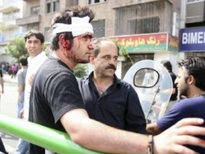 An injured protester stands on a street in Tehran